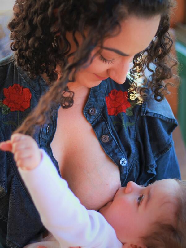curly haired woman nursing baby
